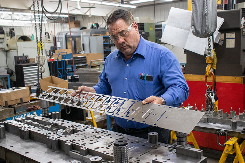 Bill Hemmelgarn Looking at a Part at Hi Tech Wire and Manufacturing